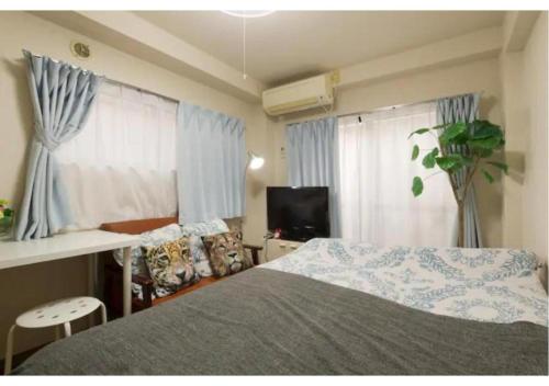 KugayamaPalace Mercy105 - Vacation STAY 11922的一间卧室配有床、电视和窗帘