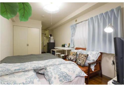 KugayamaPalace Mercy105 - Vacation STAY 11922的一间卧室配有两张床、一张桌子和一台电视。
