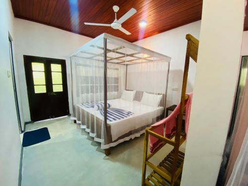 迪克韦勒drongo place的一间卧室配有一张天蓬床和吊扇