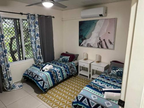维拉港Bamboo Villa的客房设有两张床和窗户。