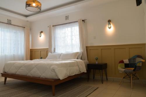 RuiruGuesthouse in Kamakis Eastern Bypass的一间卧室设有一张床、一个窗口和一把椅子