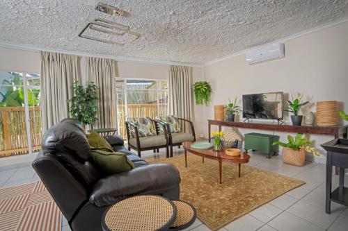 内尔斯普雷特美叶Spa酒店的客厅配有真皮沙发和电视