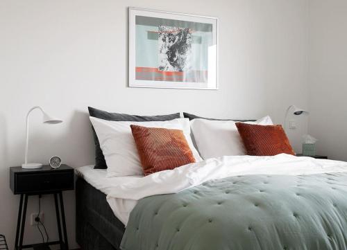 塔林W Apartments Uus-Hollandi with sauna的一间卧室配有带白色和橙色枕头的床