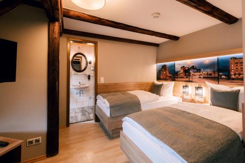 艾恩贝克Hotel Einbecker Hof的酒店客房设有两张床和盥洗盆