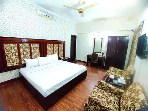 伊斯兰堡Margalla View Motel的一间卧室配有一张床、一把椅子和一张沙发