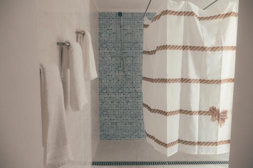 马托西纽什Oportocean Hostel的带淋浴和浴帘的浴室