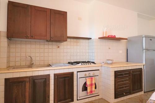 帕图Case Vacanze San Gregorio的厨房配有木制橱柜和炉灶烤箱。