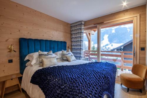 莫尔济讷Chalet Tilly的一间卧室设有蓝色的床和窗户。