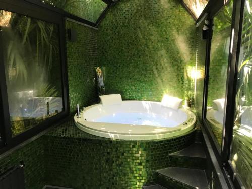 陶尔米纳伊索克旅馆的一间绿色瓷砖浴室,内设浴缸