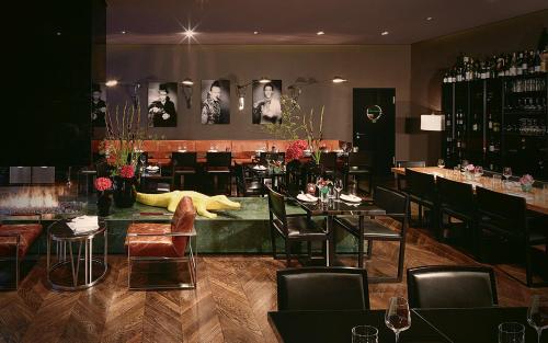 柏林Hotel MANI by AMANO的一间带桌椅的餐厅和一间酒吧