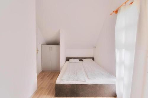 巴拉通雷勒Villa Oliver Balatonlelle的一间白色的小房间,里面设有一张床