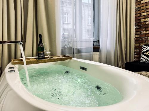 克拉科夫Apartment Premium Jacuzzi for couples, Old Town的浴缸内备有一瓶葡萄酒