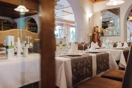 贝旺罗特乐切霍夫酒店的餐厅设有2张带白色桌布的桌子