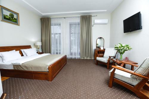 苦盏Khujand Grand Hotel的配有一张床和一把椅子的酒店客房