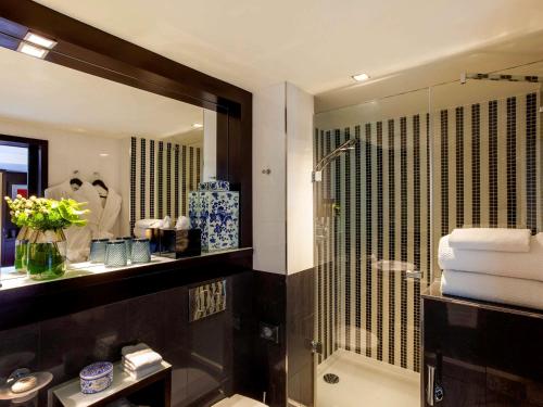 里斯本里斯本索菲特大饭店的带淋浴、盥洗盆和镜子的浴室