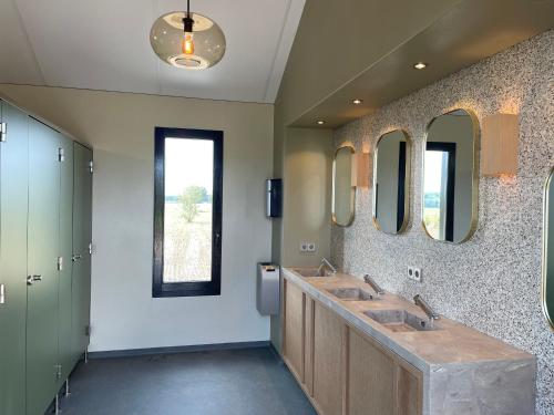 邦尼克Camping de Vliert的浴室设有2个水槽和2面镜子