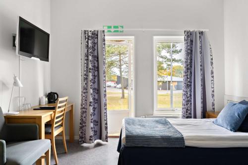 哈尔姆斯塔德Tyleback Hotell; Sure Hotel Collection by Best Western的一间卧室配有一张床、一张书桌和一个窗户。