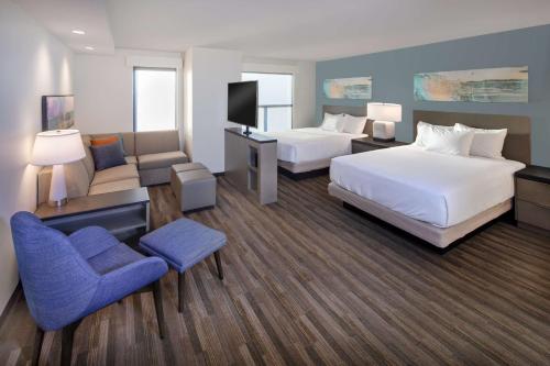 刘易斯Hyatt House Lewes Rehoboth Beach的酒店客房,配有两张床和椅子