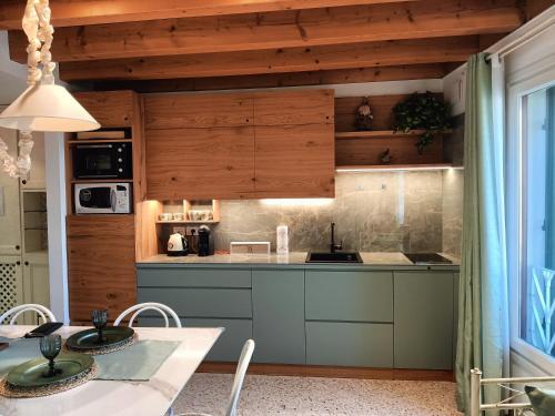 特雷维索圣莱昂纳多拉蒂娜套房公寓的厨房配有木制橱柜和桌椅