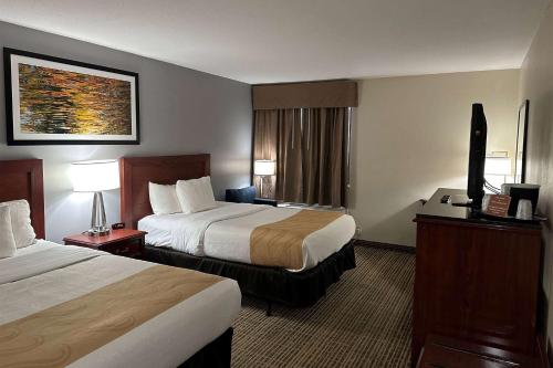 南本德Baymont by Wyndham South Bend Near Notre Dame的酒店客房设有两张床和电视。