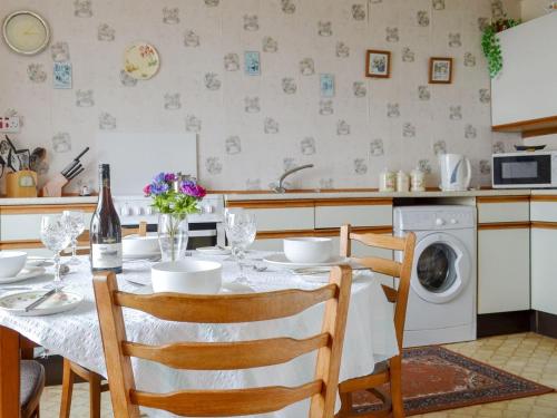 塔伯特Tigh Mairi的厨房配有桌子和洗衣机。