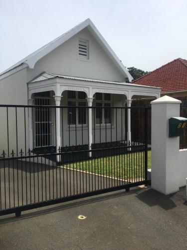 德班The Travel Inn Durban的白色房子前面的黑色围栏