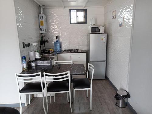 皮什丹吉Cabañas Mediterraneas的厨房配有桌椅和冰箱。