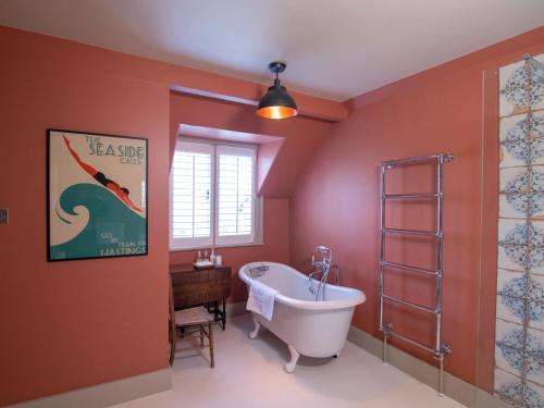 拉伊Red Cottage B&B的带浴缸的浴室和墙上的海报