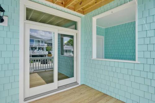 来特斯维比奇Henderson Haven 4 BR / 3 BA Villa, Steps to Beach的蓝色的房子,设有2个窗户和阳台