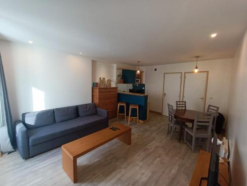 Tournan-en-BrieTournan en Brie, centre ville, superbe appartement的客厅配有蓝色的沙发和桌子