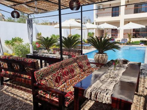 卢克索CASA LOKO Guest House的一个带桌椅的庭院和一个游泳池