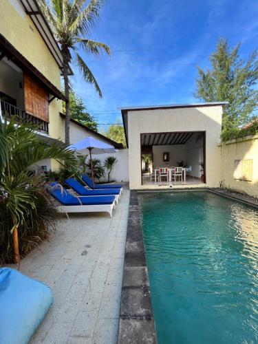 吉利特拉旺安Villa Cinta Family的一个带蓝色椅子的游泳池