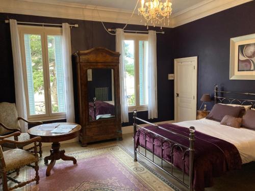 圣洛朗-德拉席琳别墅的一间卧室配有一张床、一张桌子和一个吊灯。