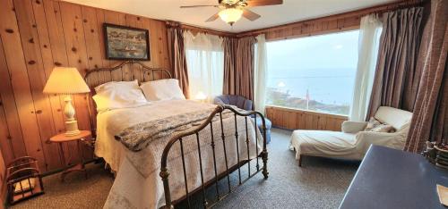 安吉利斯港PA Crows Nest Cottage的卧室配有床、椅子和窗户。