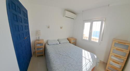 哈维亚la ventana al mar的一间卧室设有蓝色的床和窗户。