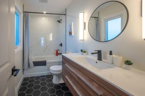 基奇纳Kingsdale Designer Tiny House with Tesla Charger的一间带水槽、卫生间和镜子的浴室
