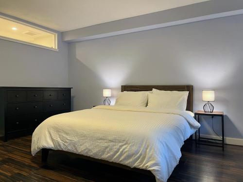 布鲁克林Close to all! 2-room suite in a 1-family townhouse的一间卧室配有一张带两盏灯的大型白色床。