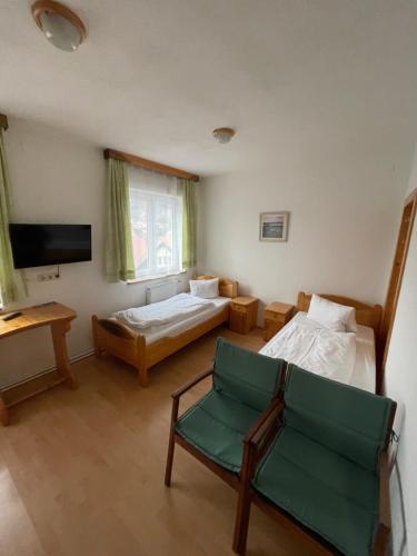 卡普芬贝格Waldrestaurant VIDA的客房设有两张床、椅子和电视。