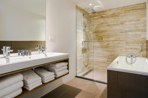 布罗门代尔Bloemendaal Hotel Collection Apartments的一间带水槽、浴缸和淋浴的浴室