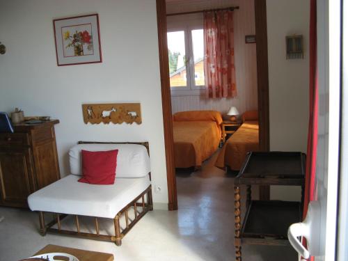 丰罗穆Chalet les lupins-T3的一间设有一张床和一把椅子及红色枕头的房间