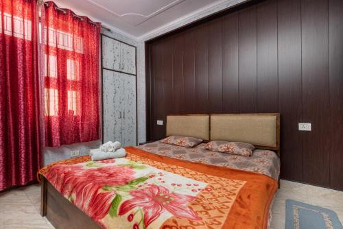 新德里(UGF)Entire Indpndnt Private 2 BHK Flat,Nr Airport的一间卧室配有一张带红色窗帘的大床