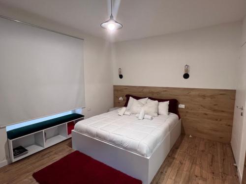地拉那Grand Park & Bllok Area Rooms的卧室配有白色的床和红色地毯。
