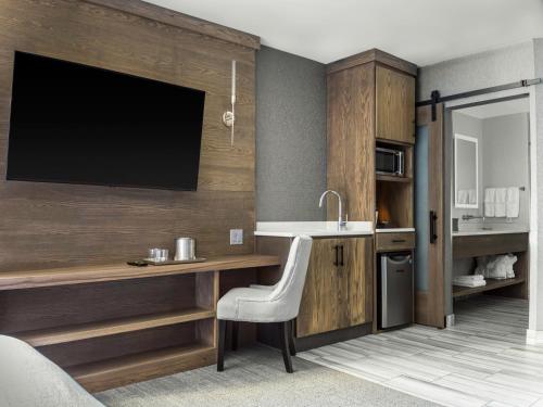 尼亚加拉瀑布voco - The Cadence, an IHG Hotel的厨房配有带水槽的书桌和电视。