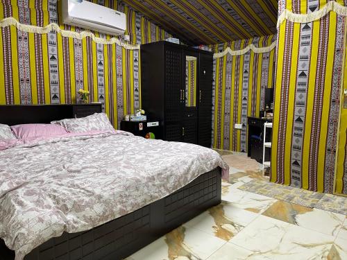 مزرعة دريم للتأجير的卧室配有一张床铺,位于一个黄色墙壁的房间