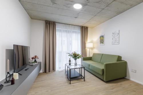 马达伯乐斯拉夫Aparthotel Na Klenici的客厅配有绿色沙发和电视