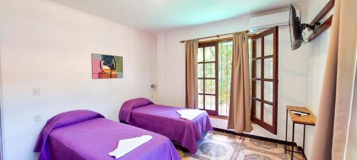 伊瓜苏港Orquídeas De La Selva的客房设有两张床和窗户。