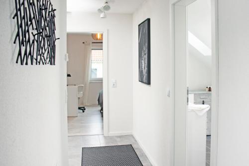 罗拉赫BlackNCozy - Design Appartement mit Boxspringbett und Balkon的走廊上设有白色的墙壁和黑白的艺术作品