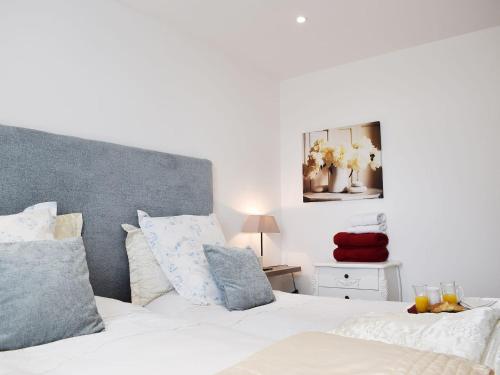 利文-法夫Bramble Cottage的一间卧室配有带白色床单和蓝色枕头的床。