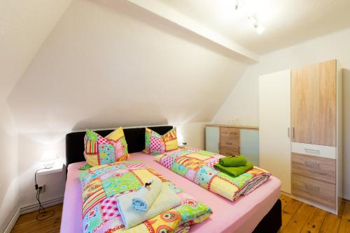 奎德林堡Harztour 2 Ferienwohnung的一间卧室配有两张带色彩缤纷枕头的床