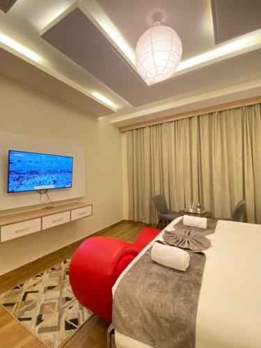 艾卜哈فندق جولدن توليب أبها - GOLDEN TULIP ABHA HOTEl的一间卧室设有一张大床和一台墙上的电视。